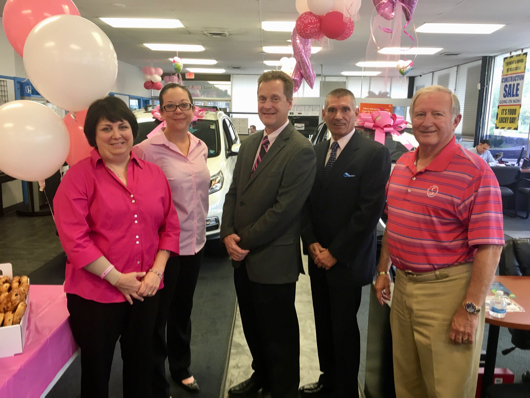North Fork Breast Health Coalition president Susan Ruffini, left with Apple Honda controller Dawn Vogel, Riverhead Supervisor Sean Walter, Apple Honda general manager Bill Fields and Riverhead Town assessor Paul Leszczynski at the dealership's breast cancer awareness month kickoff day on Monday. Courtesy photo