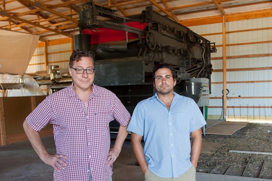 Pat Libutti, left, and Marcos Ribeiro inside the storage and processing barn at Craft Master Hops in Mattituck, with the 10,000-pound harvester they had shipped from Germany. Photo: Katharine Schroeder